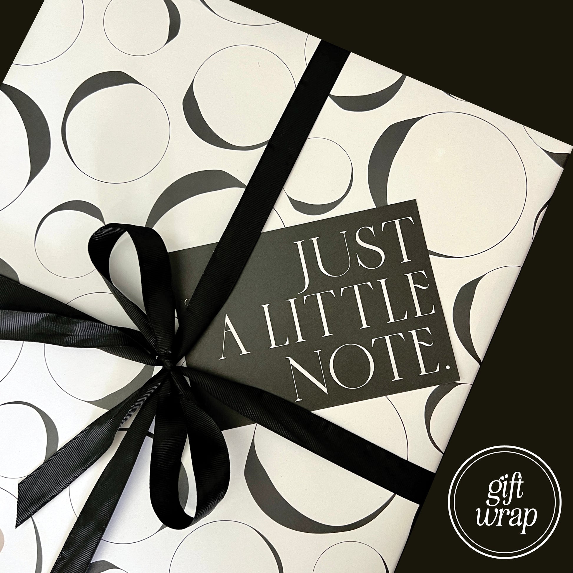 Example of gift wrapping used when paid for. White and black Aballone Paper, finished with black ribbon and gift note