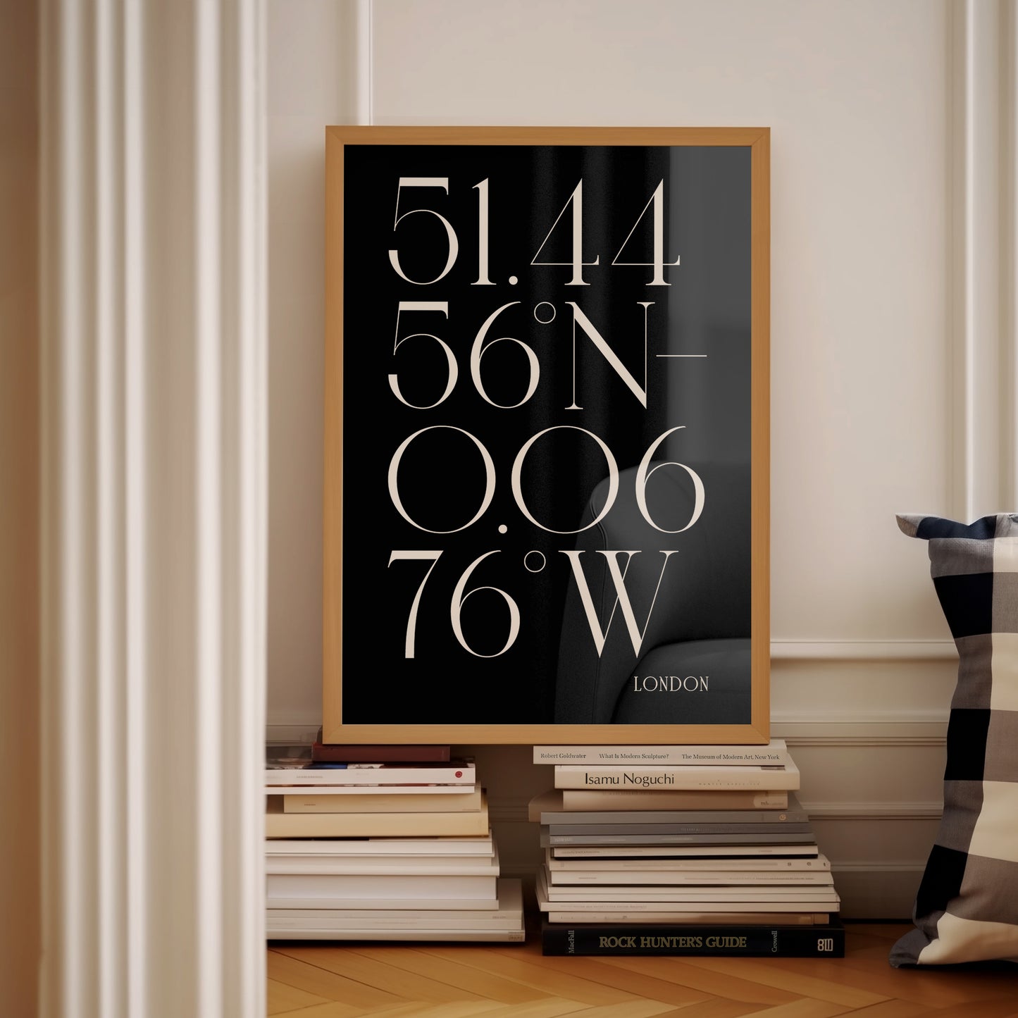 Black and white Deco coordinate print London anniversary gift in wooden frame. On top of stack of books in high class looking house