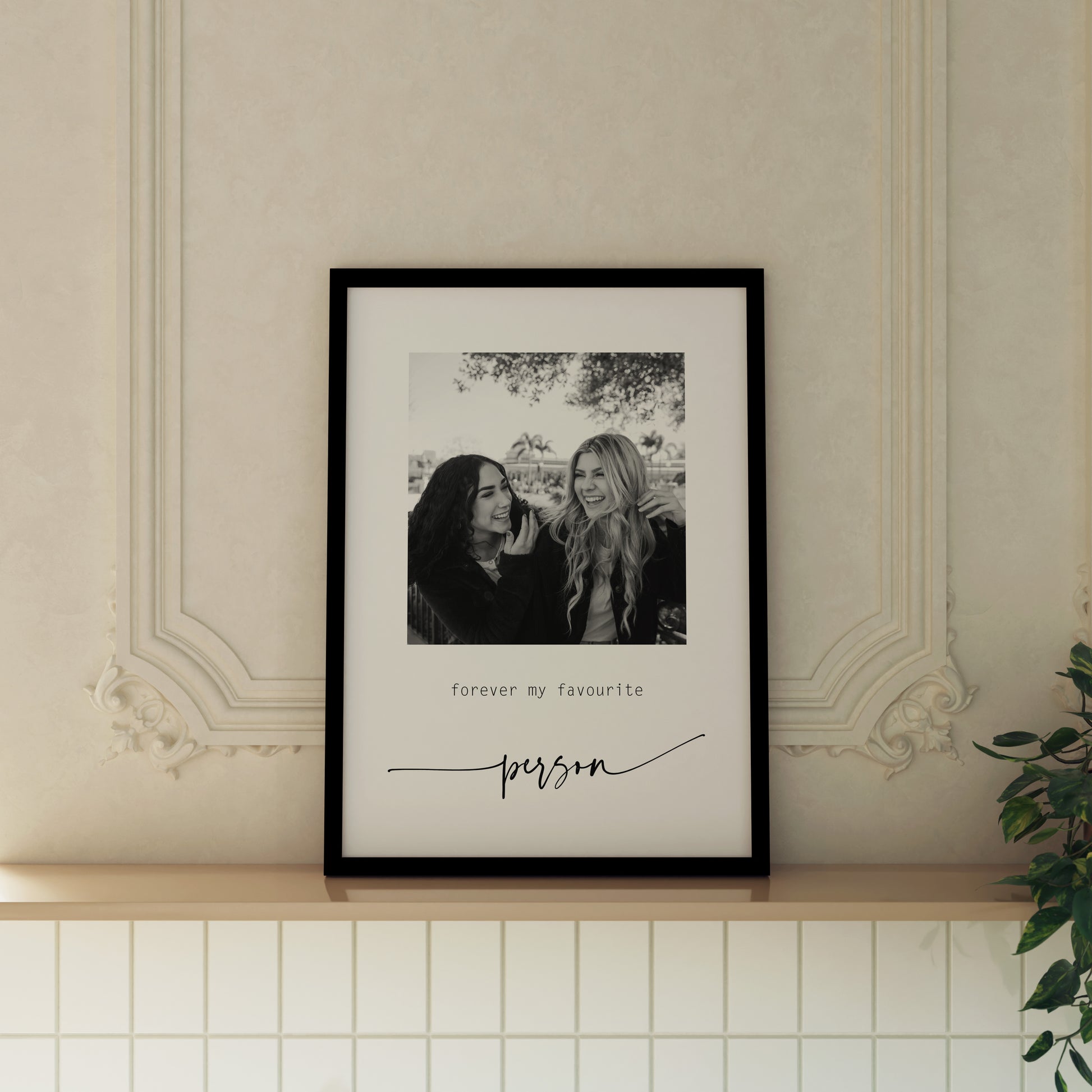 Photo print of 2 girls laughing with the text "Happy Birthday Bella" below. This is a custom print from Aballone Studio. Print is framed and featured on a ledge in a cream kitchen