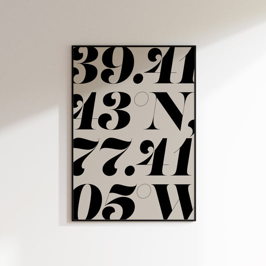 A location coordinate print for the home, ideal for hallways, living rooms and bedrooms. This is a neutral beige coloured print with slate coloured number coordinates falling off all edges of the print in a bold serif typeface. Print is in a black frame on a white wall background.