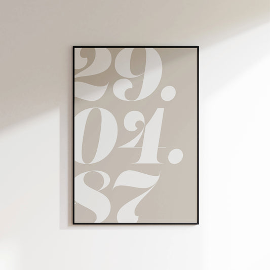 A date number print for the home, ideal for hallways, living rooms and bedrooms. This is a neutral beige coloured print with a white coloured serif date falling off the left hand side of the print. Print is in a black frame on a white wall background.